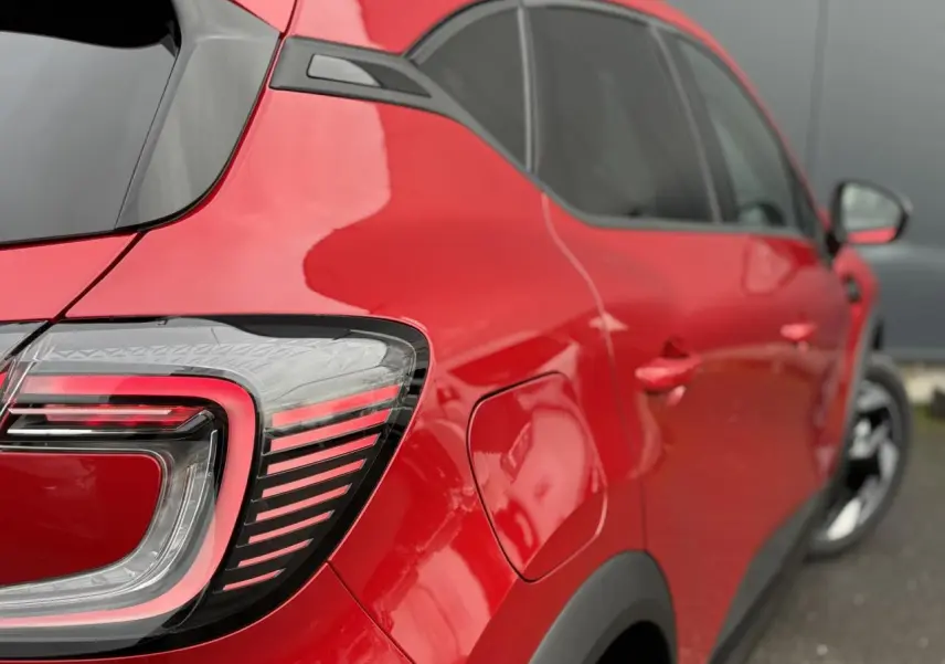 Vue arrière côté gauche du Renault Captur 2026 rouge Flamme avec feux LED et jantes aluminium noires.