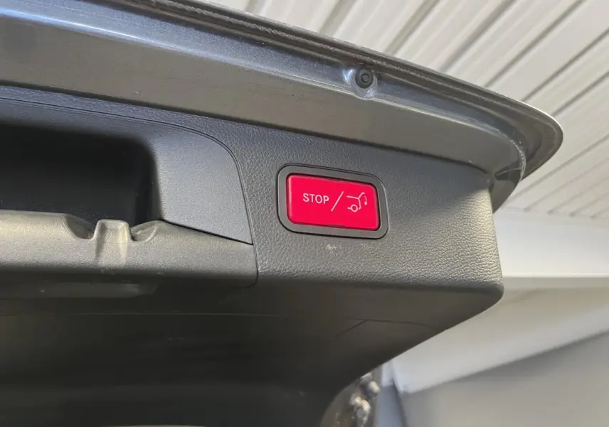 Bouton rouge d'arrêt d'ouverture du hayon sur le coffre gris d'un Mercedes GLC 220 d Sportline 2019.