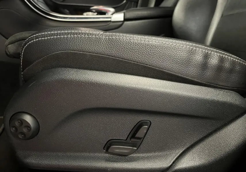 Détail de la commande électrique du siège avant en cuir noir du Mercedes GLC 220 d Sportline 2019.