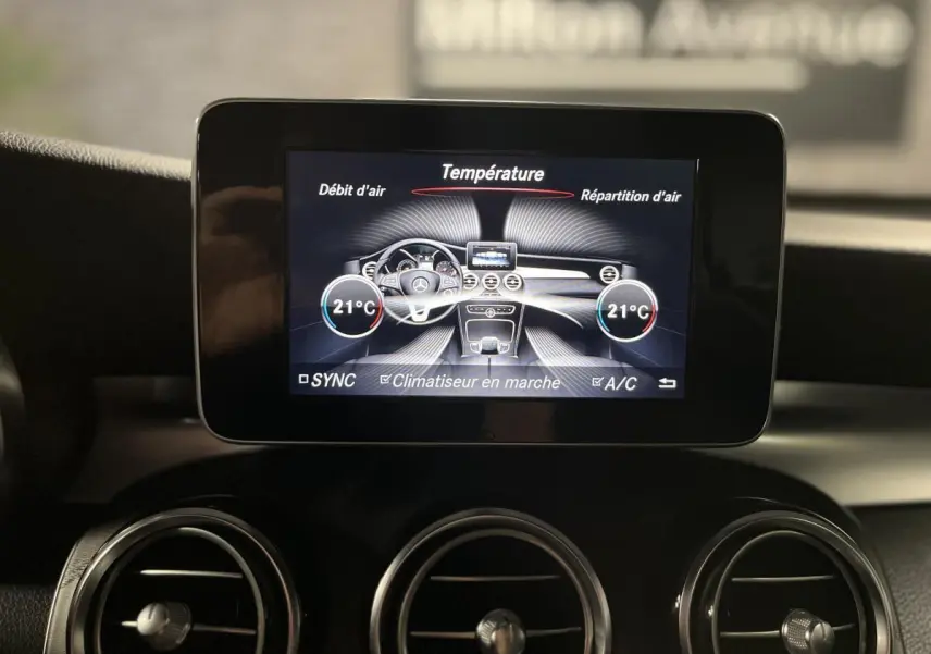 Écran central du tableau de bord du Mercedes GLC 220 d 2019 affichant la climatisation à 21°C, avec aérateurs ronds chromés.