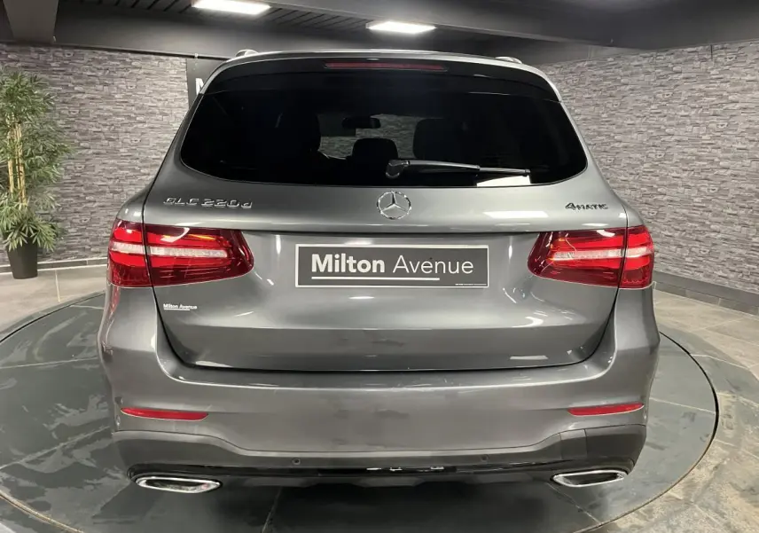Vue arrière d'un Mercedes GLC 220 d gris métallisé avec feux LED et double sorties d'échappement chromées.
