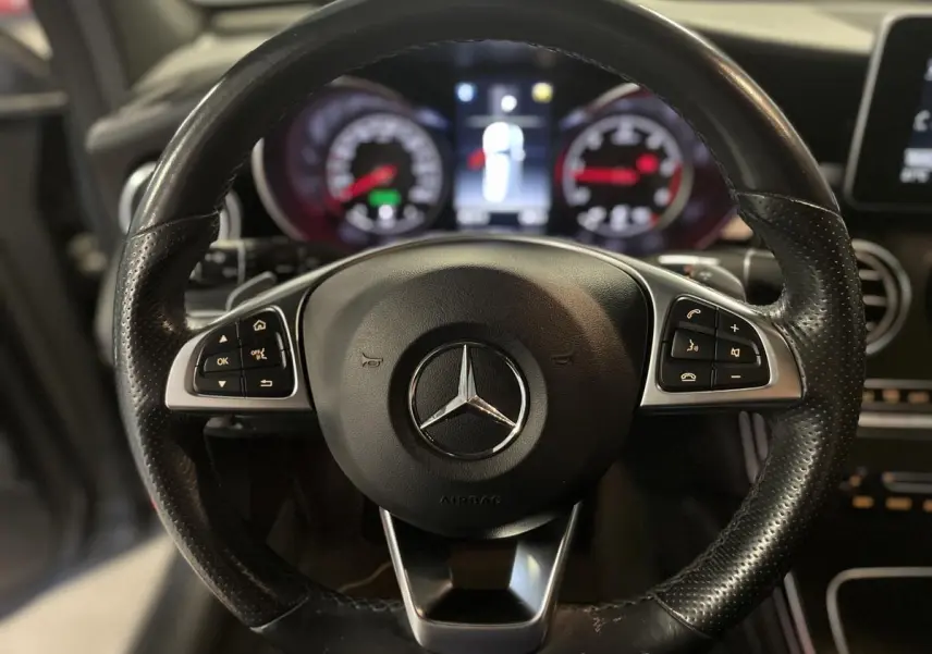 Volant sport en cuir perforé de Mercedes GLC 220 d Sportline 2019, avec commandes multifonctions visibles côté gauche.
