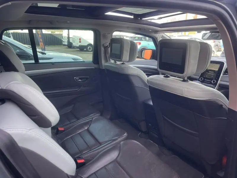 Vue intérieure arrière droite du Renault Espace gris Cassiopée, montrant les sièges individuels et écrans intégrés aux appuie-têtes avant.