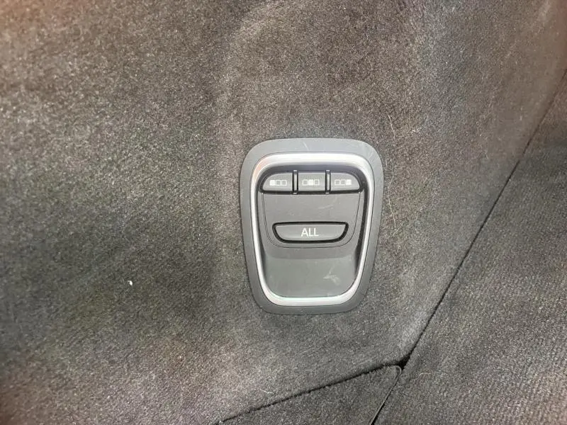 Gros plan sur les commandes de rabattement des sièges arrière dans l'habitacle du Renault Espace gris Cassiopée.