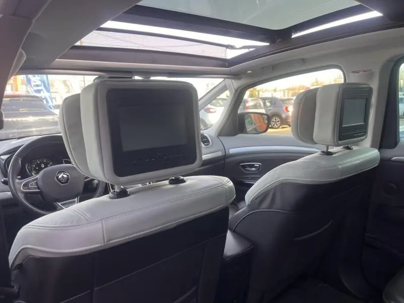 Intérieur de Renault Espace gris Cassiopée, vue arrière des sièges avant avec écrans intégrés et toit panoramique ouvert.