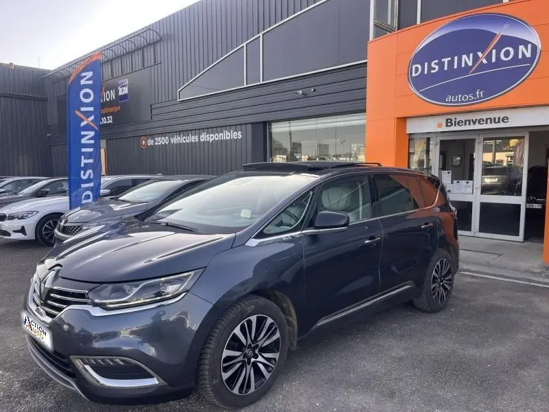 Renault Espace gris Cassiopée en 3/4 avant droit, garée devant un concessionnaire Distinxion.