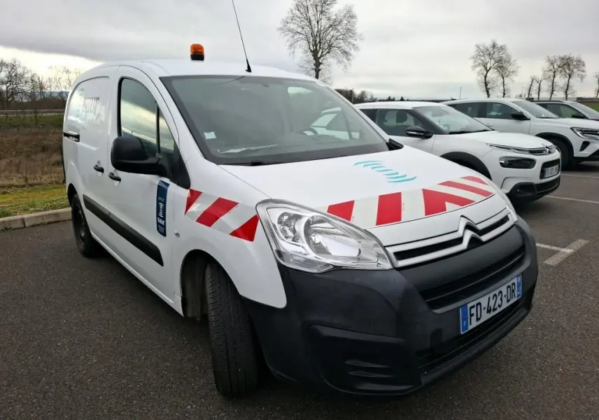Vue 3/4 avant gauche d'un Citroën Berlingo blanc utilitaire avec bandes rouges diagonales et gyrophare orange sur le toit.