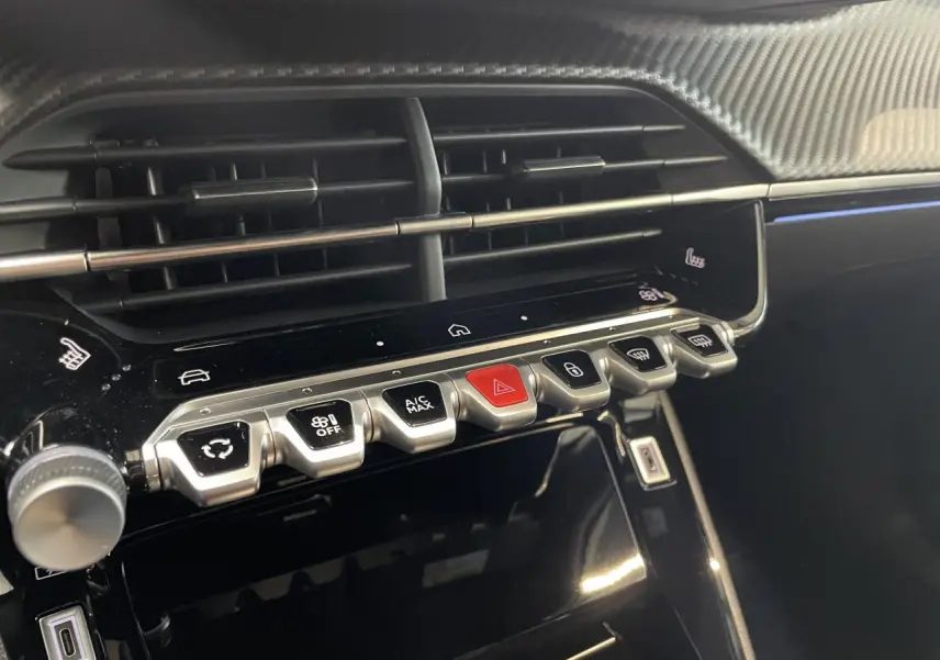 Gros plan sur la console centrale du Peugeot 2008 gris 2026, montrant les commandes tactiles et les aérateurs horizontaux.