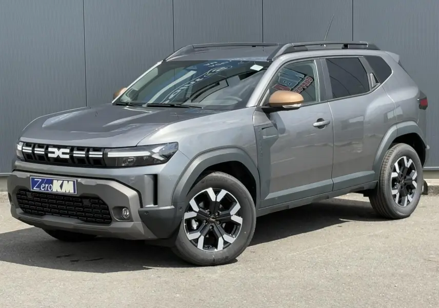 SUV Dacia Duster gris schiste en 3/4 avant droit avec coques de rétroviseurs brun cuivré et jantes alliage.