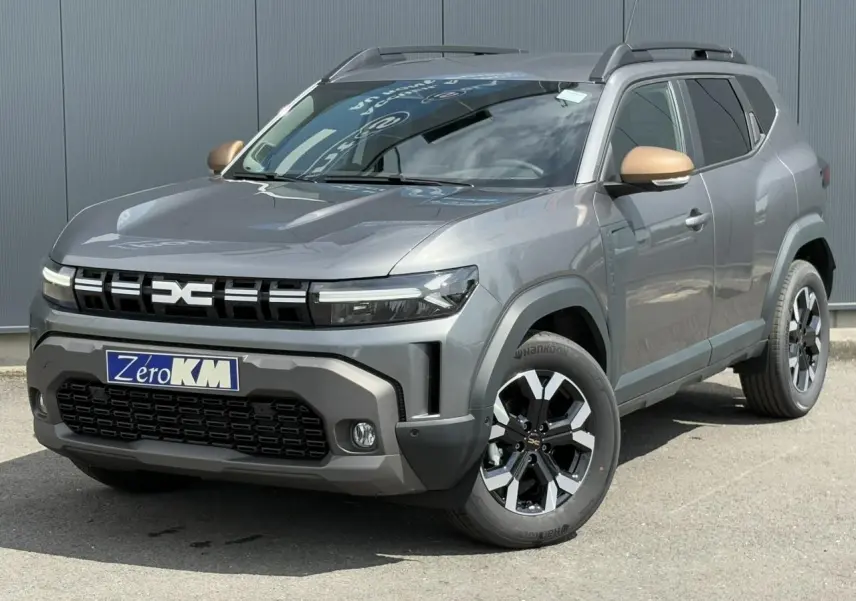 SUV Dacia Duster gris schiste en 3/4 avant droit avec coques de rétroviseur brun cuivré et jantes alliage noires.