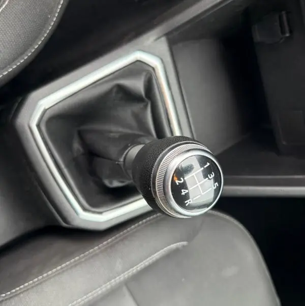 Le levier de vitesse manuel noir de la Dacia Sandero SCe 65 Confort 2021 vu en gros plan depuis l'intérieur.