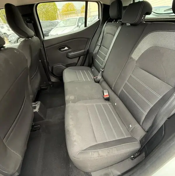 Vue intérieure arrière droite des sièges noirs et gris de la Dacia Sandero blanche 2021 SCe 65 Confort.