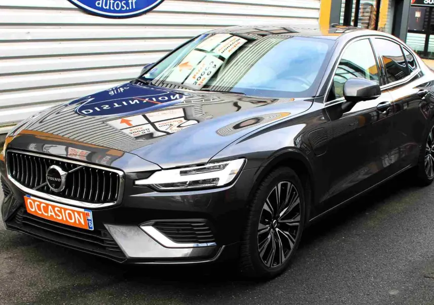 Volvo S60 gris métal vue 3/4 avant droit, calandre chromée et jantes alliage distinctives visibles.