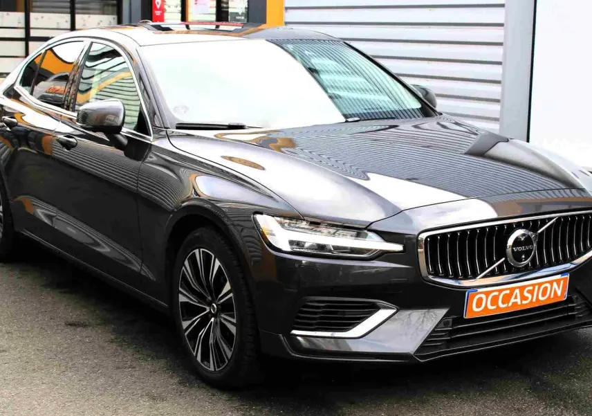 Volvo S60 hybride rechargeable gris métal vue 3/4 avant droit avec calandre chromée et plaque "OCCASION".