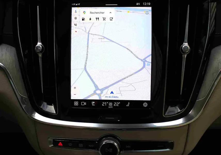 Écran tactile central avec navigation GPS dans l’habitacle beige d’un Volvo S60 gris métal 2024 hybride rechargeable.