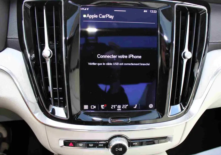 Écran central tactile du tableau de bord du Volvo S60 gris métal 2024, affichant Apple CarPlay et commandes climatisation.