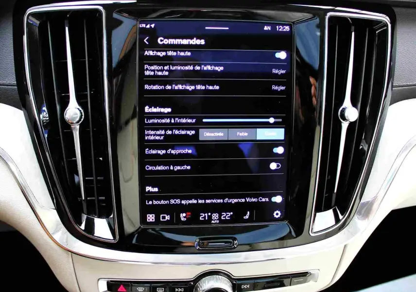 Écran tactile central avec commandes d’éclairage dans l’habitacle clair d’une Volvo S60 gris métal 2024.
