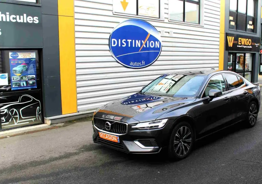 Volvo S60 T6 hybride rechargeable gris métal vue 3/4 avant droit devant un concessionnaire Distinxion.