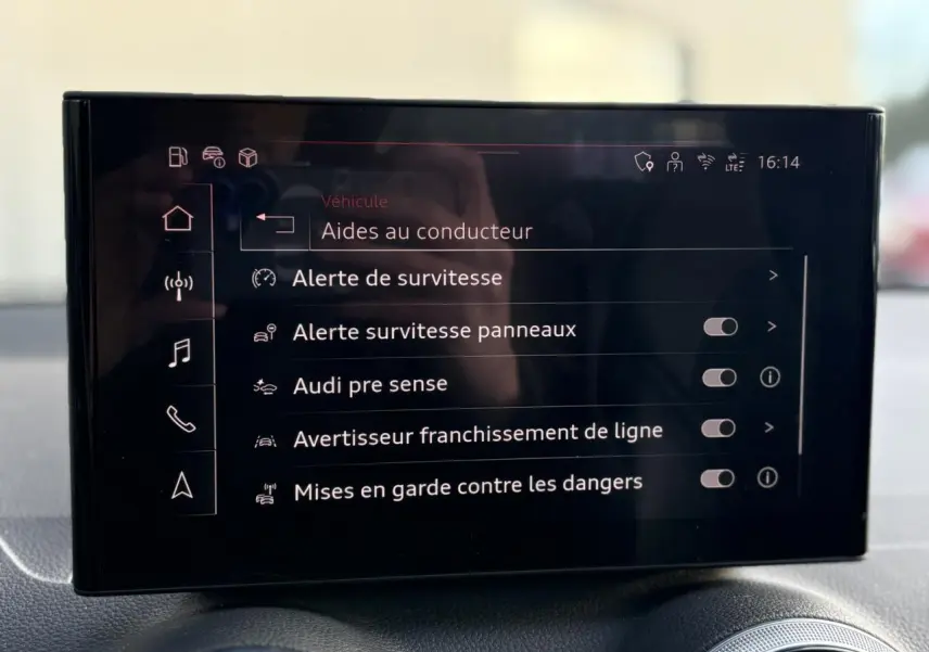 Écran central de l’Audi Q2 35 TDI 150 S-Tronic S-Line affichant les aides à la conduite, intérieur noir.