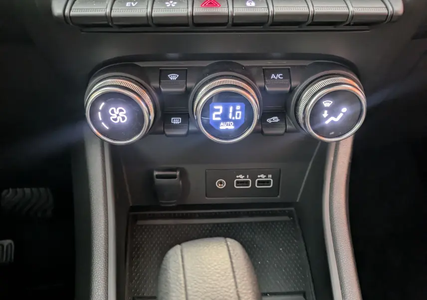 Gros plan sur la console centrale du Renault Captur II Techno 2023, montrant les commandes de climatisation automatique et ports USB.