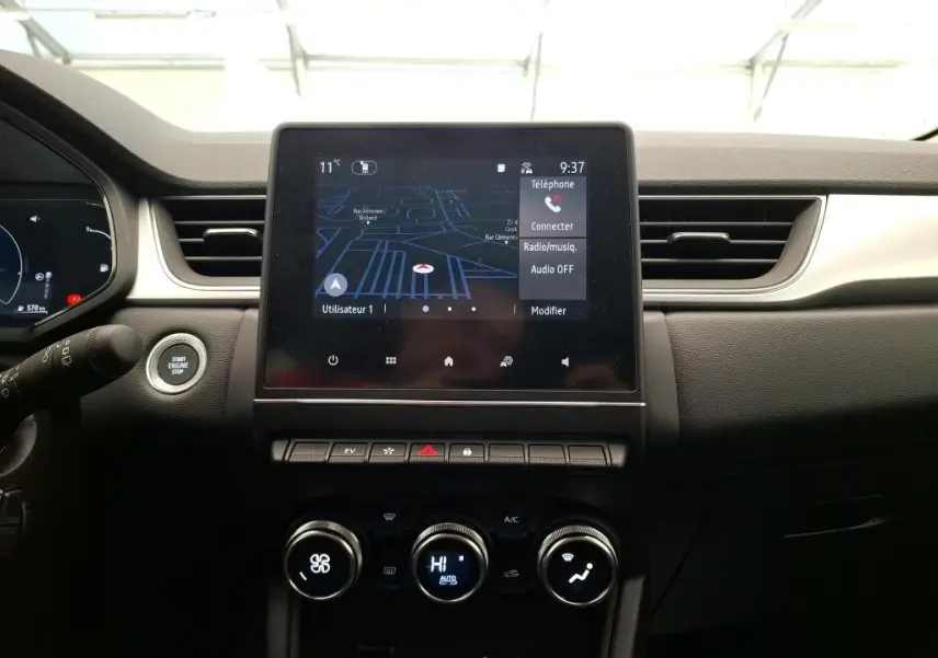 Coffre ouvert vu de l'arrière d'un Renault Captur gris Highland 2023, montrant l'espace de chargement vide.