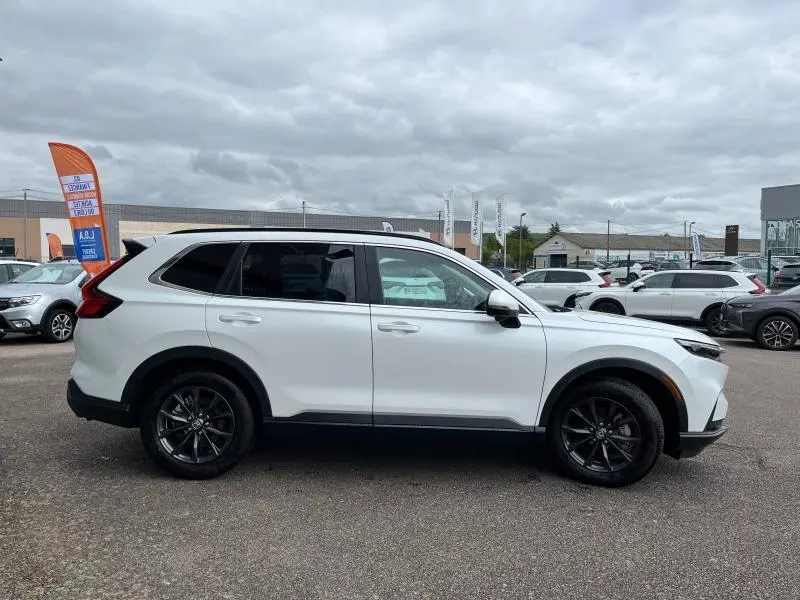 Honda CR-V 2024 blanc platine nacré vu de profil côté gauche avec jantes alliage noires et vitres teintées.