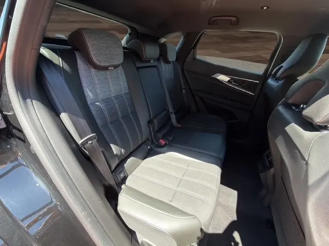 Vue intérieure côté gauche des sièges arrière en tissu et cuir gris du Renault Austral noir, avec ceinture de sécurité visible.