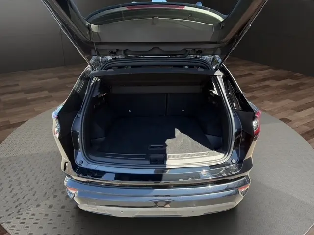 Vue arrière ouverte du coffre noir du Renault Austral 2025, soulignant l'espace de chargement généreux et l'intérieur sombre.