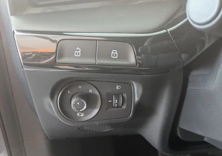 Gros plan sur les commandes de réglage des rétroviseurs et verrouillage, intérieur noir du MG MOTOR MG3 2026.