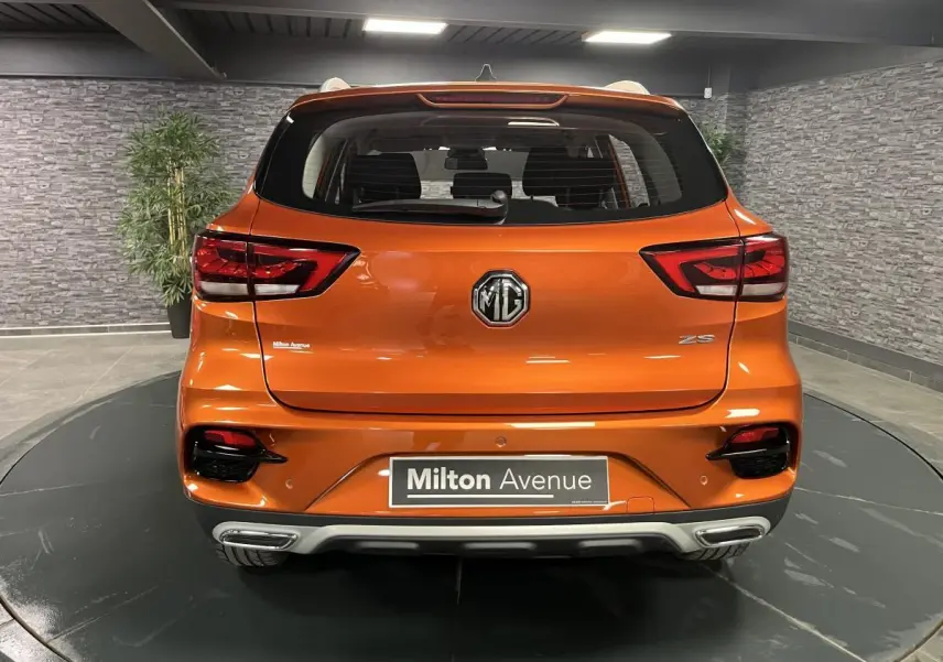 Vue arrière du SUV MG ZS 2022 orange métallisé avec feux LED et double sortie d'échappement intégrée.