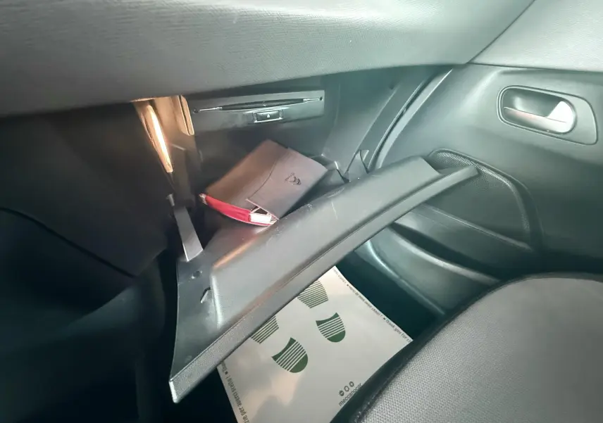 Gant de boîte à gants ouvert côté passager dans une Citroën C4 Picasso blanc de 2014 avec manuel visible.