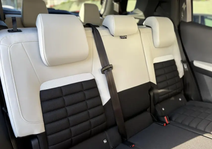 Vue rapprochée des sièges arrière bicolores noir et gris clair du Citroën C3 Aircross Hybrid 2025 en configuration 7 places.