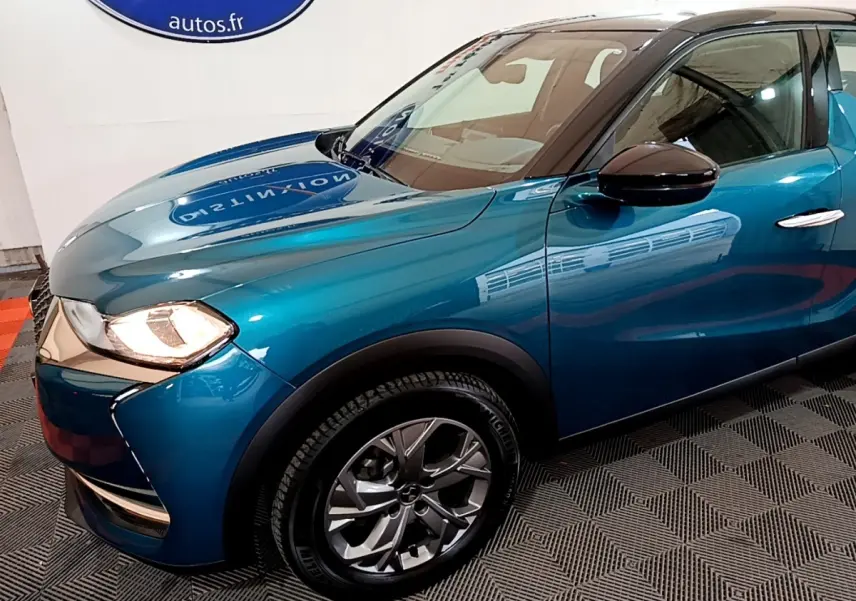 Vue 3/4 avant gauche d'un DS3 Crossback bleu avec phares allumés et jantes alliage modernes.
