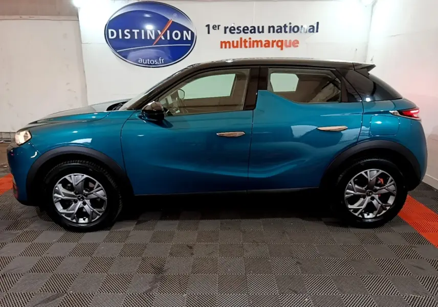 Profil côté gauche d'un DS3 Crossback bleu 2020 dans un showroom avec jantes alliage et toit noir contrasté.