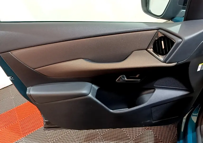 Vue intérieure côté gauche de la porte avant d'une DS3 Crossback bleu, avec garniture noire et sortie d'air angulaire.