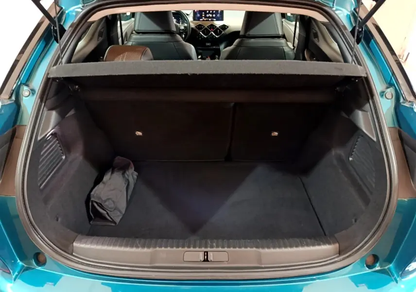 Coffre ouvert vu de l'arrière d'un DS3 Crossback bleu, avec tablette cache-bagages et intérieur noir visible.
