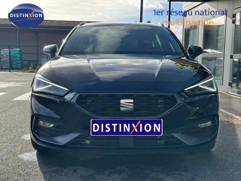 Vue frontale d'une SEAT LEON ST 1.5 eTSI Hybrid 2025 en Noir Minuit Métallisée avec calandre et phares LED distinctifs.