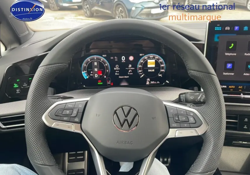 Vue intérieure centrée sur le volant cuir perforé et tableau de bord numérique de la Volkswagen Golf 2026 noire.