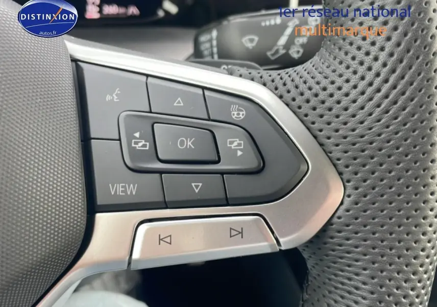 Gros plan sur les commandes multifonctions en cuir perforé du volant noir de la Volkswagen Golf 1.5 etsi evo2 150 R-Line 2026.