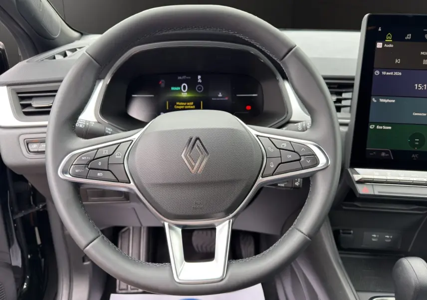 Vue rapprochée du volant noir de la Renault SYMBIOZ 2025 avec commandes multifonctions et écran tactile central visible.