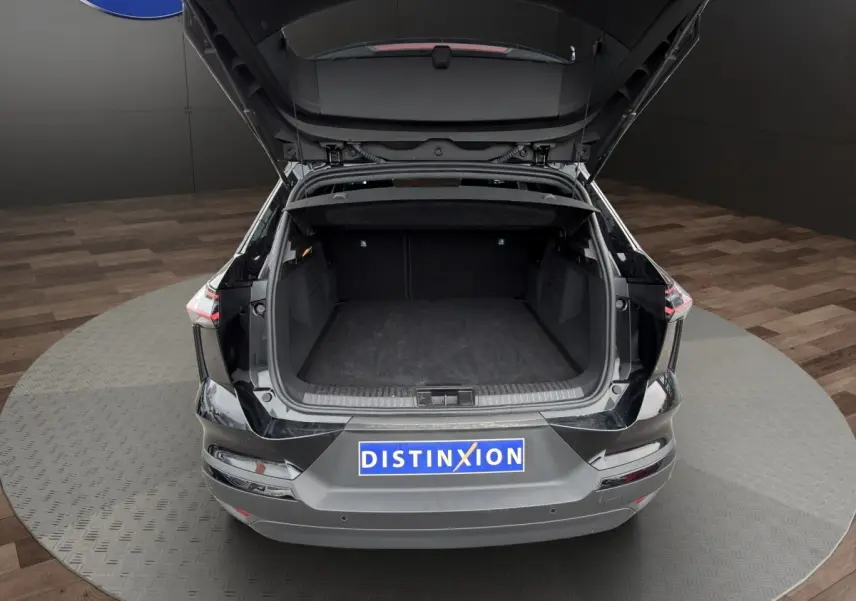 Vue arrière du coffre ouvert du Renault SYMBIOZ noir, mettant en valeur l'espace de chargement généreux et la finition soignée.