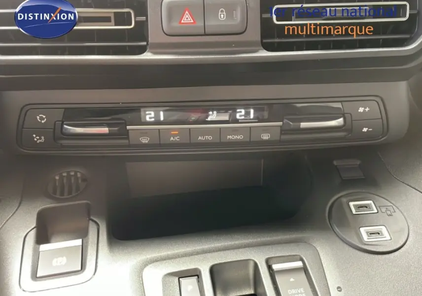Vue rapprochée de la console centrale du Citroën Berlingo gris avec commandes climatisation digitale et ports USB.