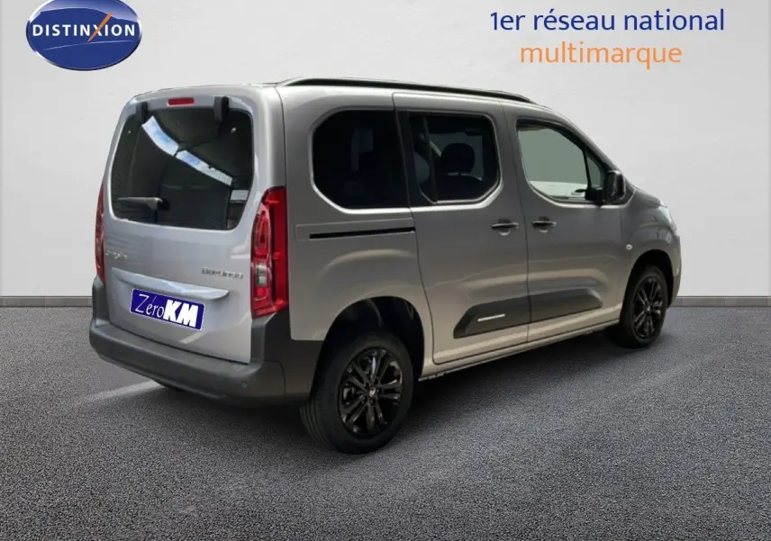 Vue 3/4 arrière droite d'un Citroën Berlingo gris Artense métal avec vitres teintées et jantes noires.