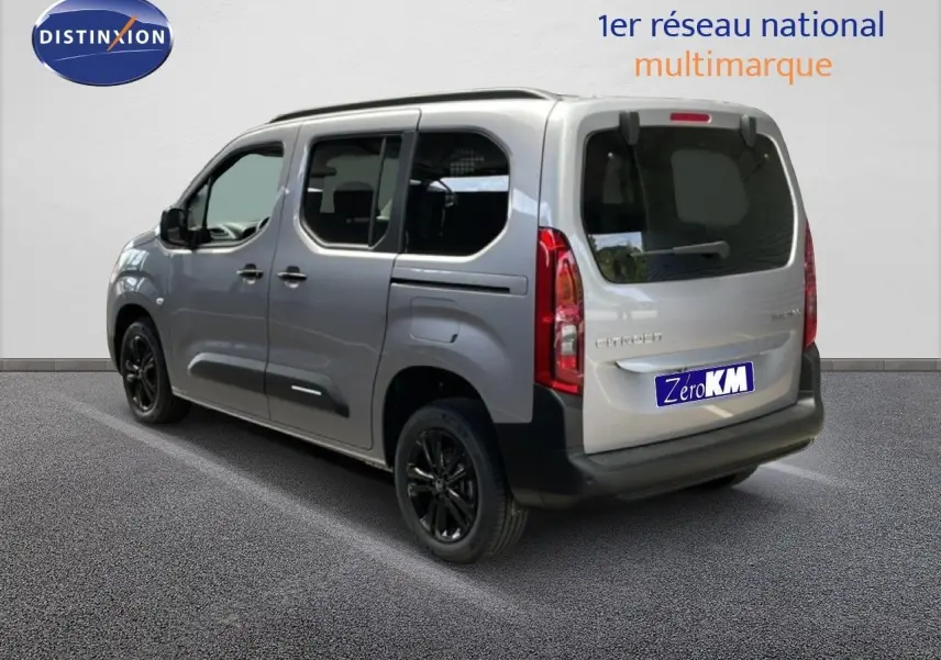 Vue 3/4 arrière droite d'un Citroën Berlingo gris Artense métallisé avec jantes noires et vitres teintées.