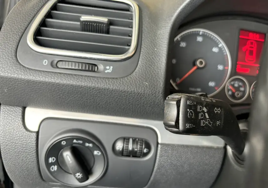 Détail du tableau de bord côté gauche du Volkswagen EOS 2008 avec commandes d'éclairage et levier de régulateur de vitesse.