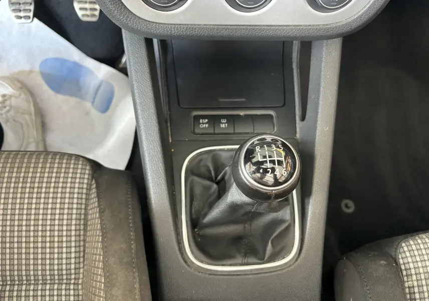 Vue rapprochée de la boîte manuelle noire et du levier de vitesses dans l'habitacle d'une Volkswagen EOS argentée de 2008.