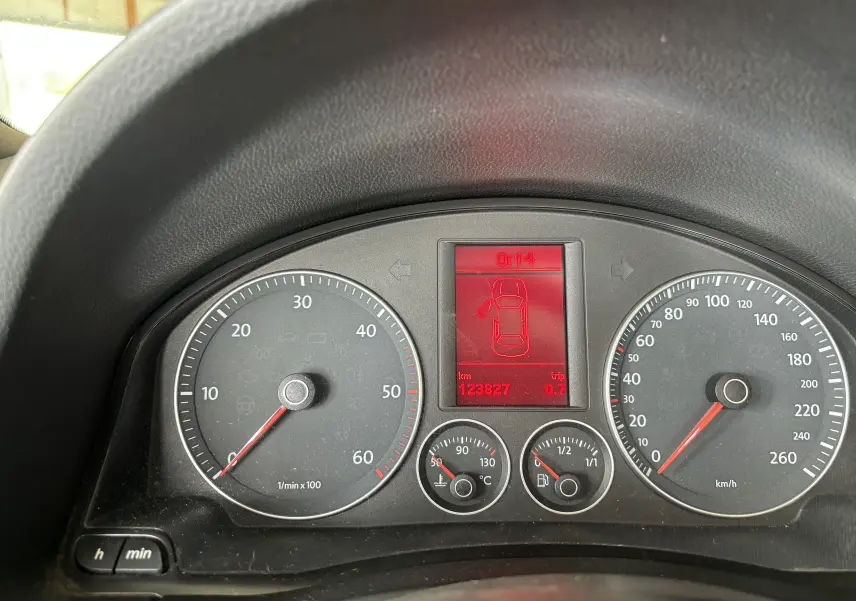 Vue rapprochée du tableau de bord du Volkswagen EOS 2008, affichage rouge indiquant porte ouverte et compteur kilométrique.