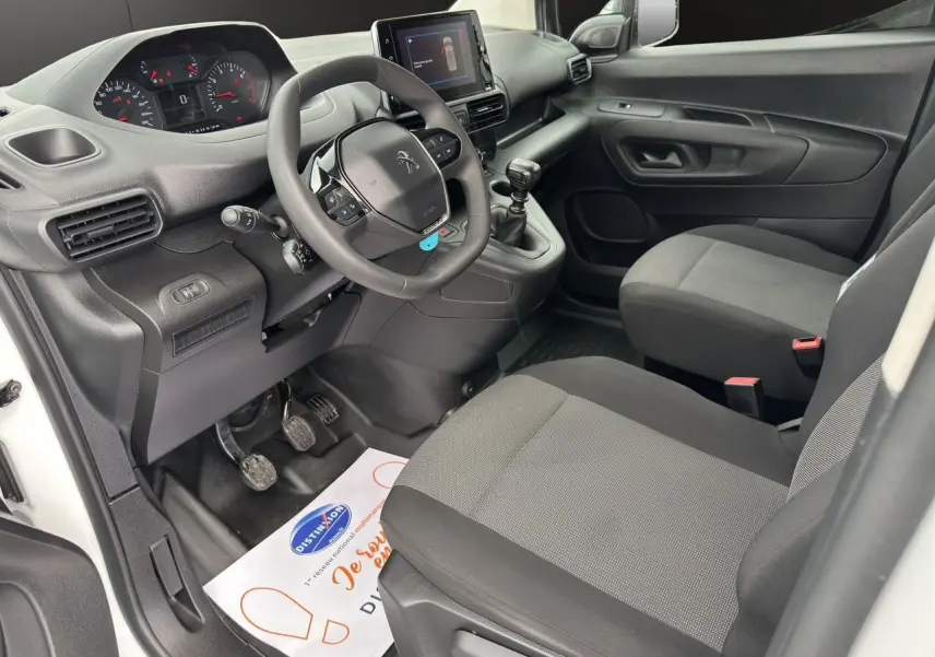 Intérieur avant droit du Peugeot Partner blanc 2022, avec tableau de bord moderne et écran tactile central.