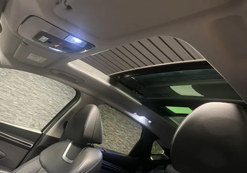 Vue intérieure du toit ouvrant panoramique et sièges avant en cuir gris du Hyundai Tucson 2023 Executive.