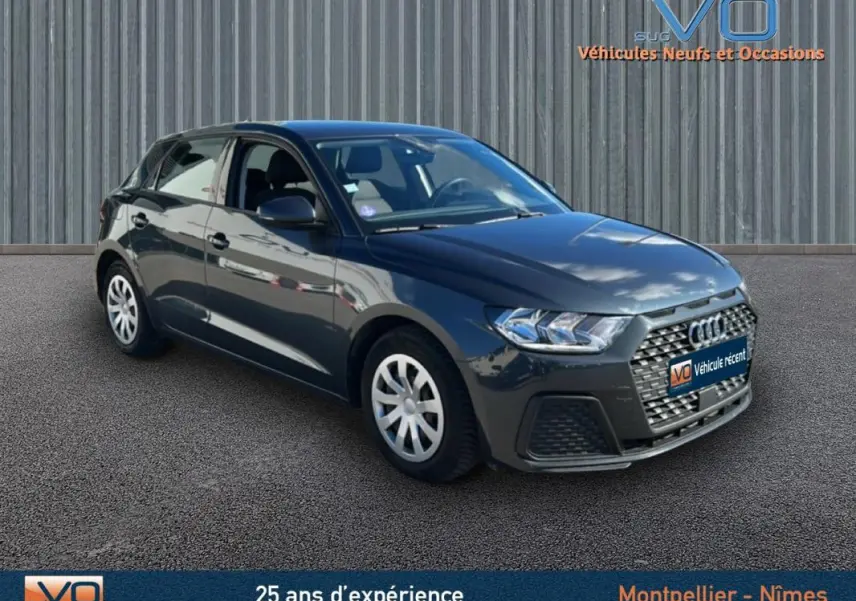 Audi A1 Sportback gris foncé vue 3/4 avant droit, avec calandre hexagonale et phares LED distinctifs.